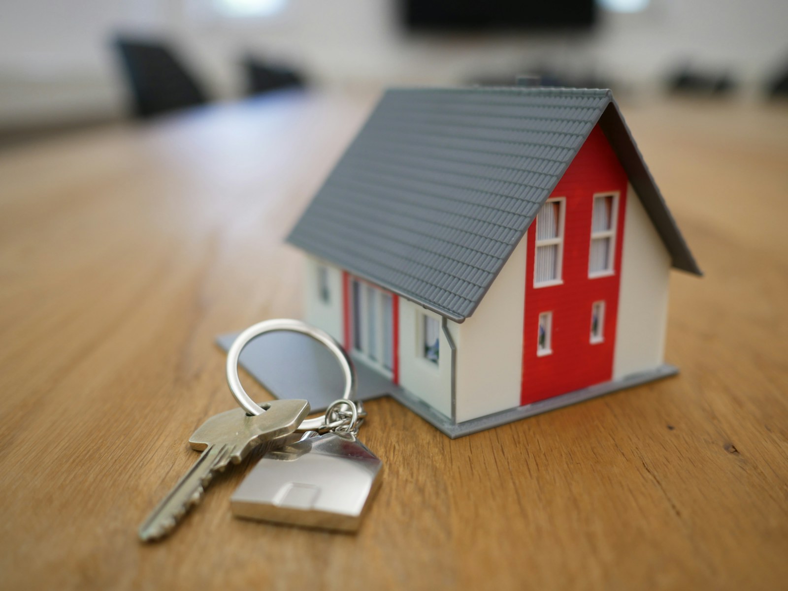 House keys beside a small home model