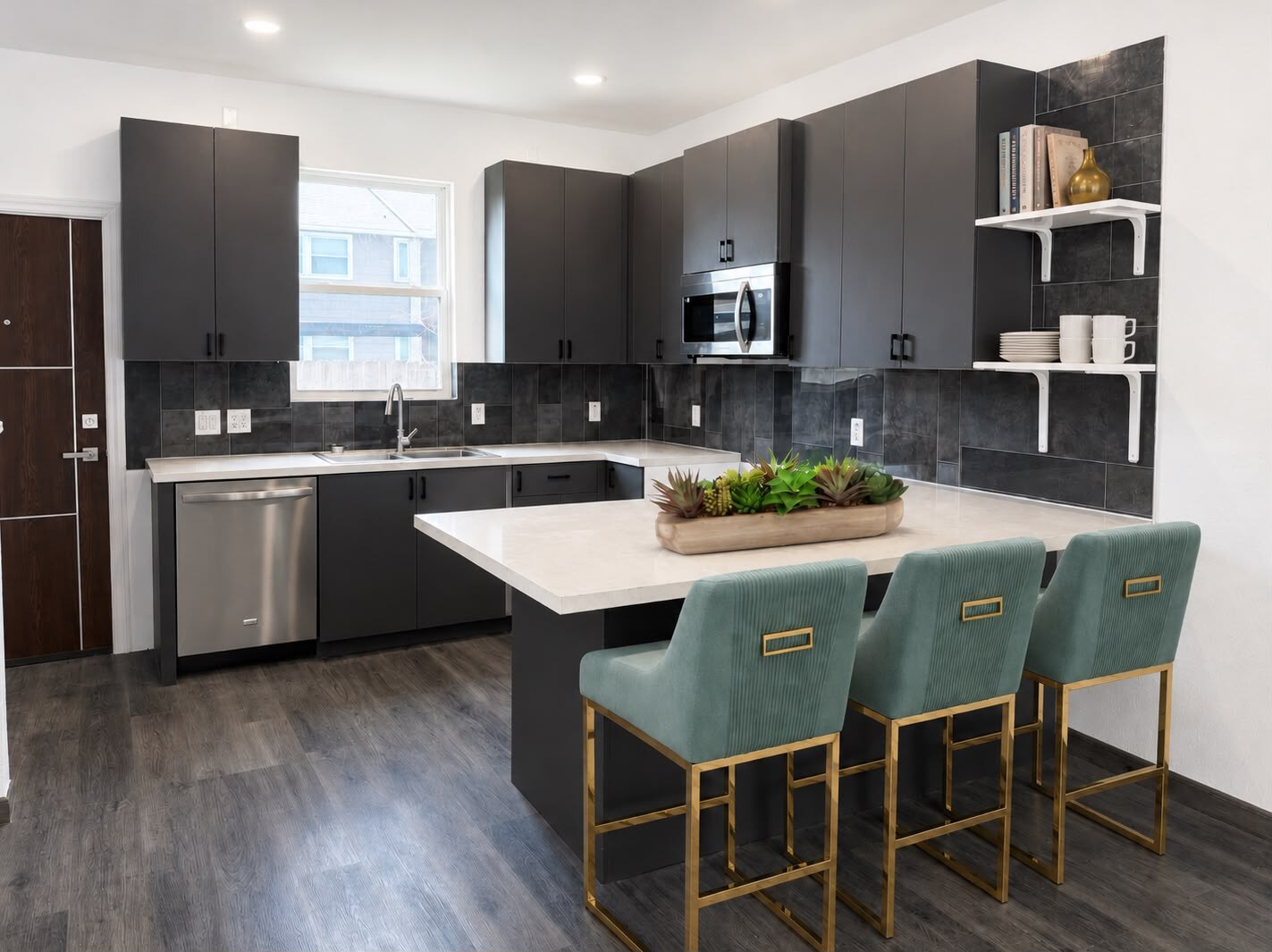 Furnished townhome kitchen with dark cabinets, island seating, and stainless appliances